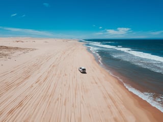 Un 4x4 su una spiaggia con le onde