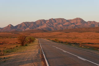 Strada attraverso un paesaggio colorato di rosso in Australia