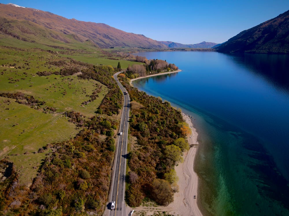 Strada tra lago blu e colline verdi Nuova Zelanda